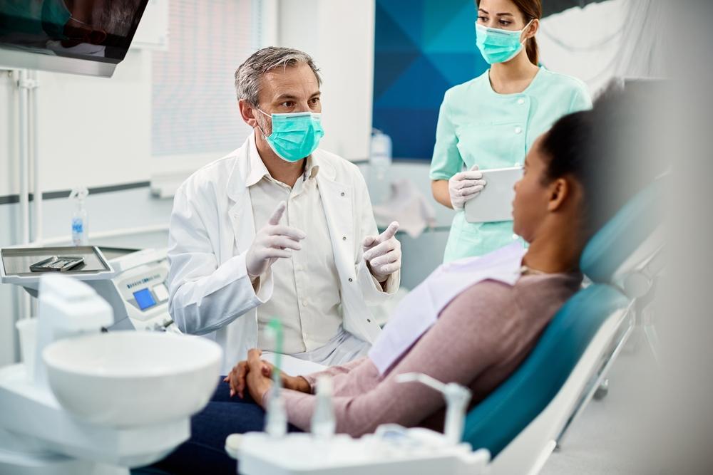 Male,Dentist,Wearing,Face,Mask,While,Communicating,With,African,American